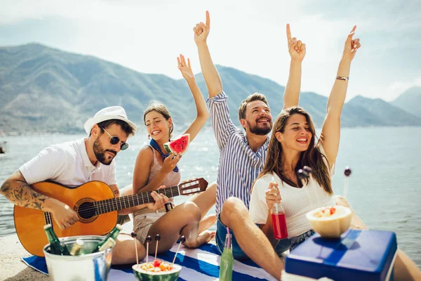 Szczęśliwi młodzi ludzie bawiący się na plaży party. — Zdjęcie stockowe