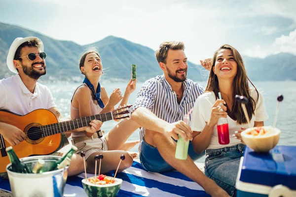 Gelukkige jonge mensen hebben plezier op het strand partij. — Stockfoto