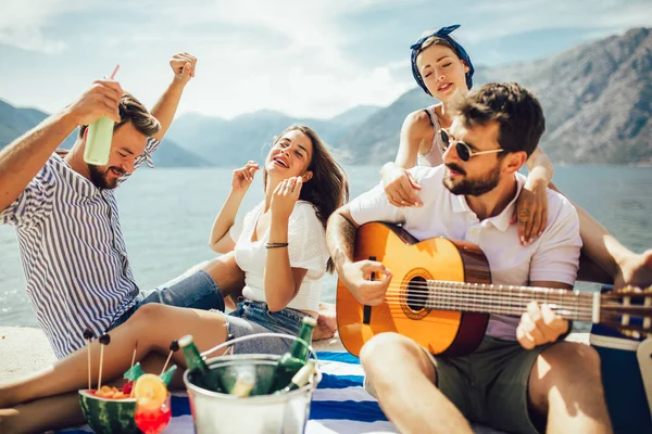 Glückliche junge Leute haben Spaß bei Beachparty. — Stockfoto