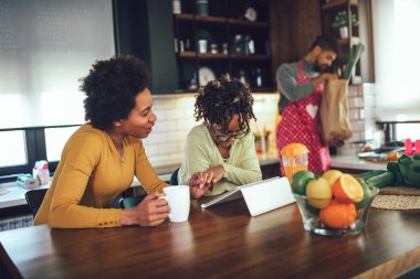 Mutfakta dijital tablet kullanarak mutlu siyah aile günleri.