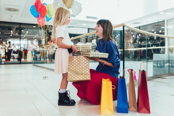 Moeder en dochter hebben plezier in het winkelcentrum samen. — Stockfoto