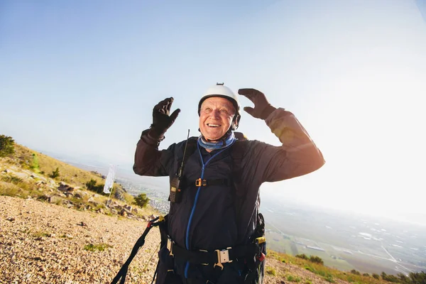 Parapente sênior ativo nos pré-pares de terra para voar . — Fotografia de Stock