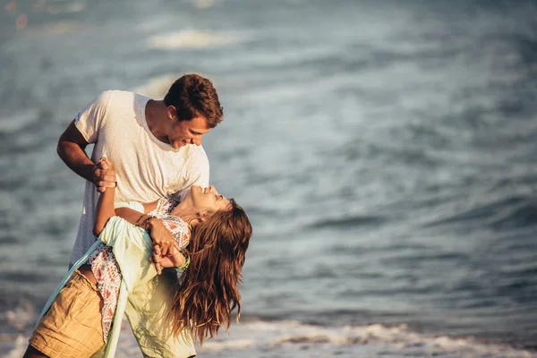 Mladý zamilovaný pár na pláži. Hezký mladý muž s dívkou — Stock fotografie