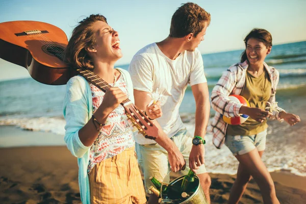 Tineri prieteni care se bucură de o plimbare pe plajă într-o zi însorită și ha — Fotografie, imagine de stoc