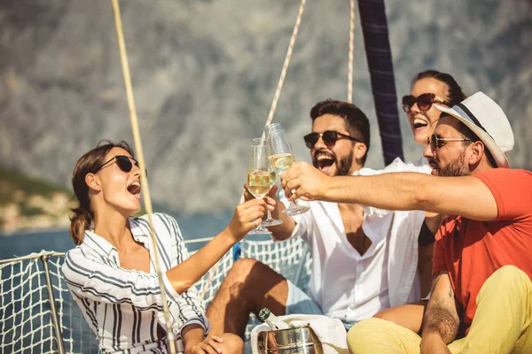 Smiling friends with glasses of champagne on yacht. Focus on gla — Stock Photo, Image