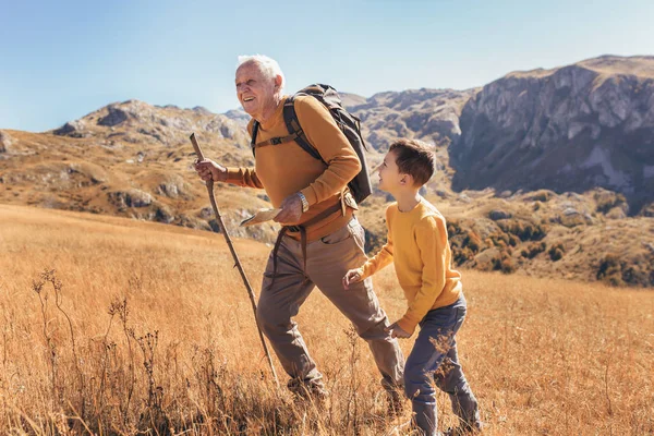 Starszy mężczyzna z wnukiem na spacerze jesienią. — Zdjęcie stockowe