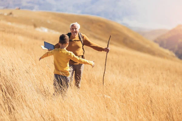 Starszy mężczyzna z wnukiem na spacerze jesienią. — Zdjęcie stockowe
