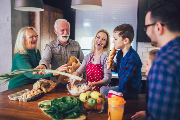 Familia feliz cocinando juntos en casa y sonriendo — Foto de Stock