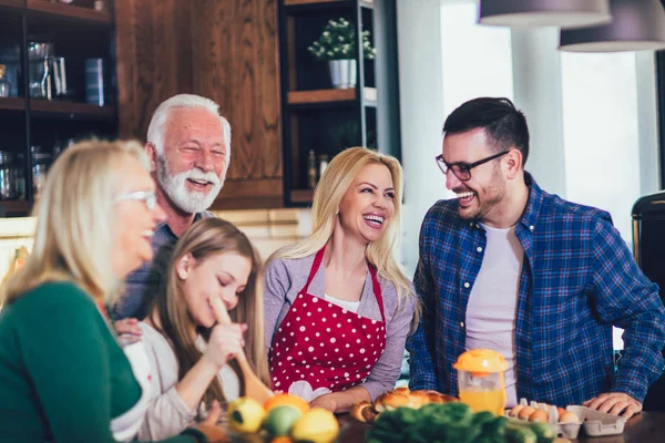 Счастливая семья готовит дома и улыбается — стоковое фото