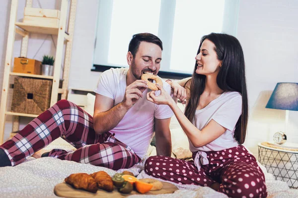 ロマンチックな幸せなカップルがベッドで朝食を持っている — ストック写真