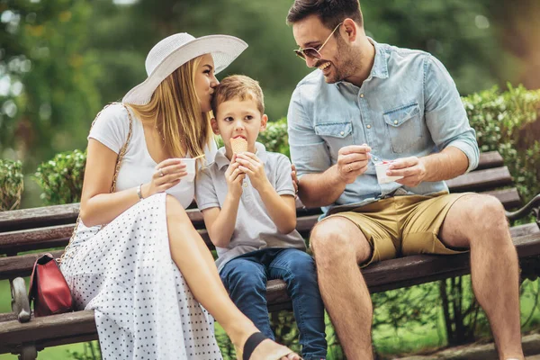 公園で週末を過ごす若い幸せな家族 アイスクリームを食べてる — ストック写真