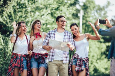 Sırt çantalı bir grup genç yolda birlikte yürüyor ve mutlu görünüyorlar.