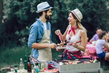 Arkadaşlar barbekü yapıyor ve öğle yemeği yiyor.