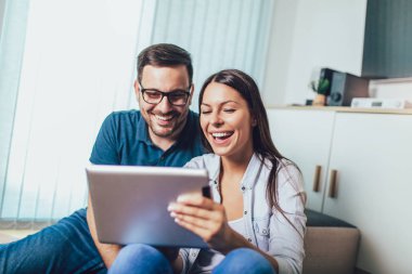 Online dijital tablet vaktinizi mutlu genç Çift.