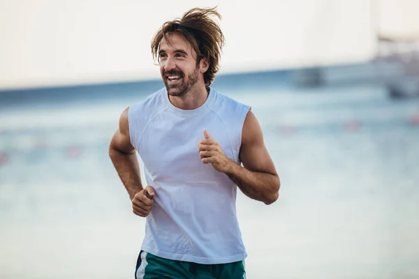 男が海岸をジョギングしている 外で働く男性ランナーの訓練 — ストック写真