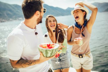 Plajda kokteyl içen arkadaşlar yaz tatilinde eğleniyorlar.