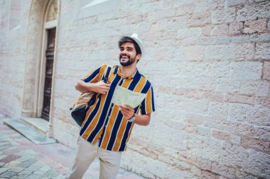 Sırt çantalı yakışıklı sakallı turist şehir boyunca seyahat ediyor..