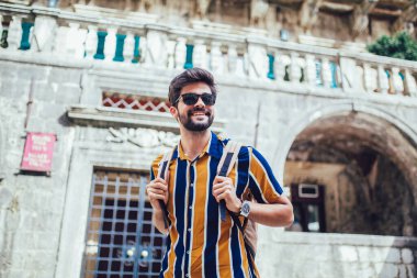 Sırt çantalı yakışıklı sakallı turist şehir boyunca seyahat ediyor..