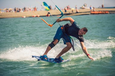 Profesyonel bir mutant nehirde zor bir numara yapar. Uçurtma sörfü yapan sörf fotoğrafçısı dalgaların arasında hızla gider.