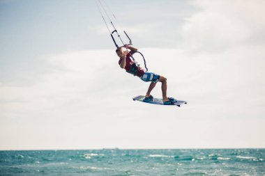 Profesyonel kiter zor hüner güzel bir arka plan üzerinde yapar. Kitesurfing Kiteboarding eylem fotoğraflar adam dalgalar arasında hızlı bir şekilde gider