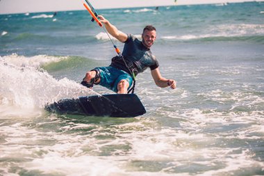 Profesyonel kiter zor hüner güzel bir arka plan üzerinde yapar. Kitesurfing Kiteboarding eylem fotoğraflar adam dalgalar arasında hızlı bir şekilde gider