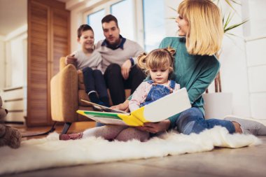 Mutlu bir aile evdeki oturma odasında eğleniyor ve gülüyor. Seçici odak.