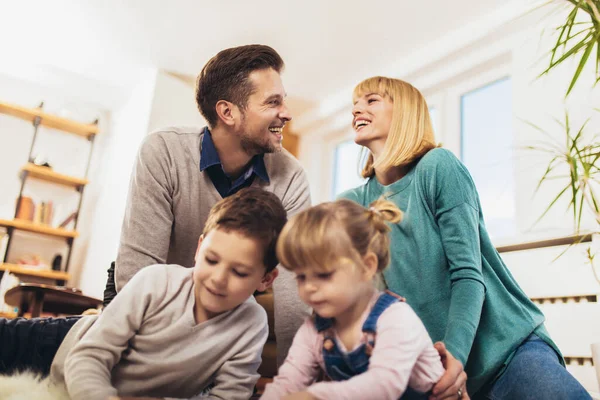 Mutlu bir aile evdeki oturma odasında eğleniyor ve gülüyor. Seçici odak.