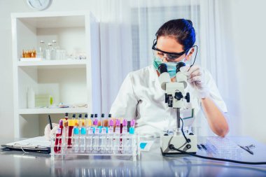 Laboratuvar teknisyeni laboratuvarda kan örneğini inceliyor. Tıbbi, farmasötik ve bilimsel araştırma ve geliştirme kavramı.