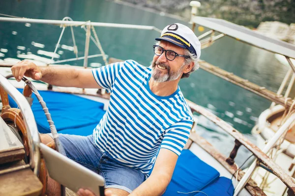 成熟した男はボートのデッキに立って 晴れた日の午後にデジタルタブレットを使用して — ストック写真
