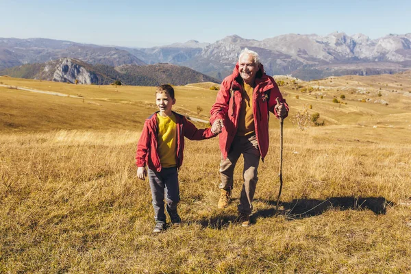 秋に田舎を歩く孫の老人 — ストック写真