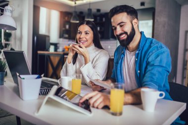 Mutlu çift evde dizüstü bilgisayarla iş yapıyor..