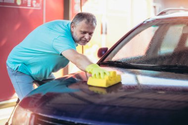 Araba yıkama. Çamaşır süngeri kullanarak araba temizleme.