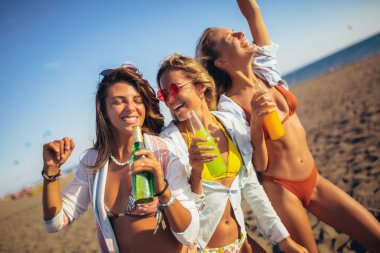 Üç güzel ve çekici genç kadın grubu sahilde eğleniyor..