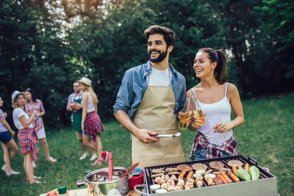 Gruppe Mennesker Stående Rundt Grill Chatte Drikke Spise - Stock-foto