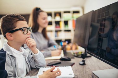 Oğlan ve kız evde çalışıyor ve okul ödevi yapıyor. Uzaklık öğrenimi çevrimiçi eğitim.