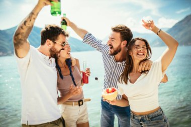 Plajda kokteyl içen arkadaşlar yaz tatilinde eğleniyorlar.