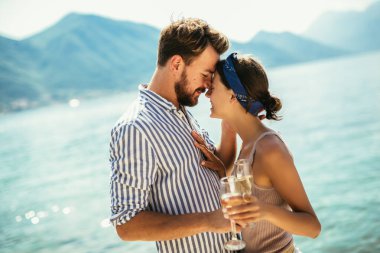 Güzel bir çift sahilde eğleniyor, kokteyl içiyor ve gülümsüyor..