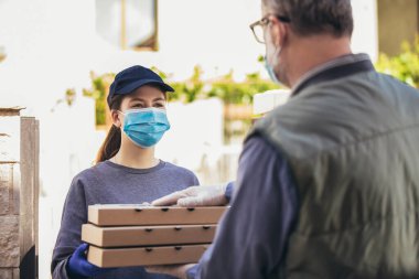 Pizza getiren kız, yaşlı bir insana koruyucu maske takıyor..