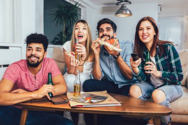 Pizza yiyen, bira içen ve televizyon izleyen bir arkadaşın fotoğrafı..