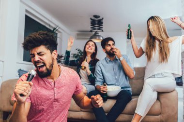 Evde karaoke yapan bir grup arkadaş. Arkadaşlık kavramı, ev eğlencesi ve insanlar
