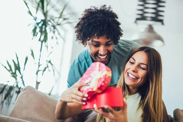 Glimlachende Man Verrast Zijn Vriendin Met Cadeau Thuis — Stockfoto