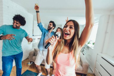 Mutlu arkadaşlar evde birlikte karaoke yapıyorlar. Bir grup arkadaş evde parti veriyor..