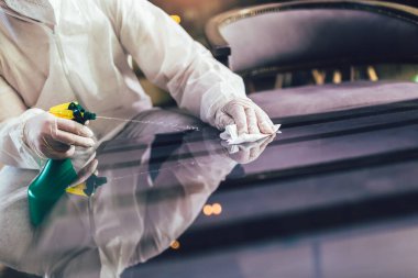 Tehlikeli madde giysileri içindeki profesyonel işçiler kafenin veya restoranın iç kısımlarını dezenfekte ediyorlar, salgın hastalık riski, koronavirüs.