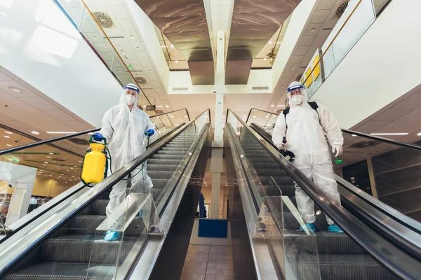 Trabajadores Profesionales Trajes Materiales Peligrosos Desinfectando Interiores Centros Comerciales Riesgo — Foto de Stock