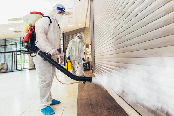 Trabajadores Profesionales Trajes Materiales Peligrosos Desinfectando Interiores Centros Comerciales Riesgo — Foto de Stock