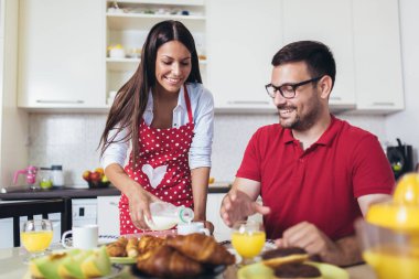 Neşeli genç çift mutfakta kahvaltı yapıyor.. 