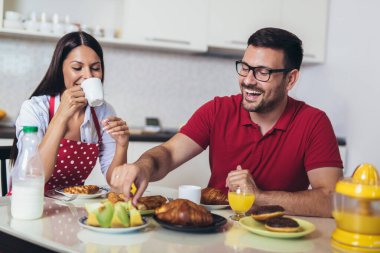 Neşeli genç çift mutfakta kahvaltı yapıyor.. 