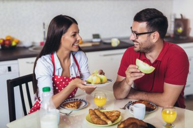 Neşeli genç çift mutfakta kahvaltı yapıyor.. 