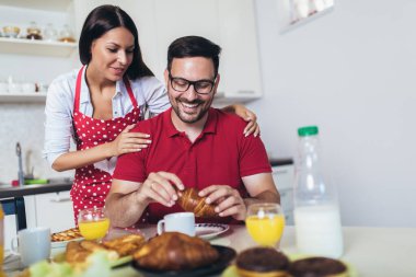 Neşeli genç çift mutfakta kahvaltı yapıyor.. 