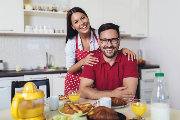家でキッチンで朝食を持っている陽気な若いカップル — ストック写真